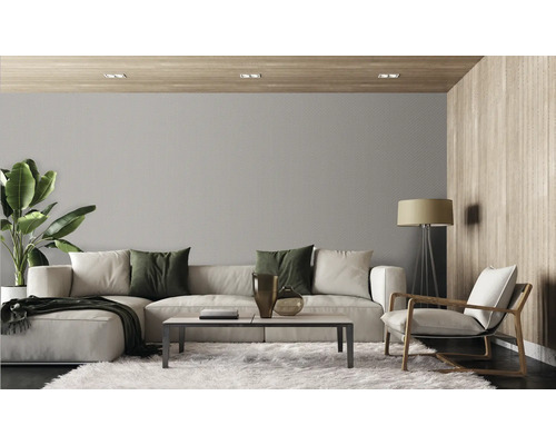 Modernes Wohnzimmer mit strukturierter Tapete, großem Sofa, Sessel, Couchtisch und Zimmerpflanze in einer organischen Einrichtung.