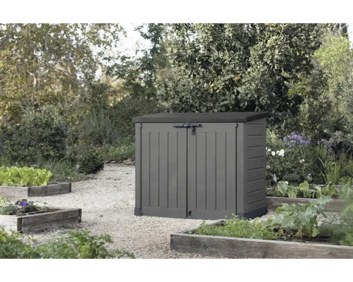 Kunststoff Gartenbox mit Doppeltür zur Aufbewahrung im Garten stehend auf einem Kiesweg vor Gartenbeeten