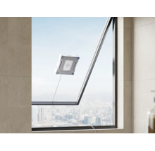 Ein Fensterputzroboter reinigt eine große Fensterscheibe mit Blick auf eine städtische Skyline.