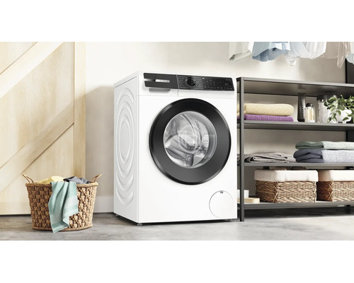 Bosch Waschmaschine in einem modernen Waschraum mit Korb, Regalen und gefalteter Wäsche.
