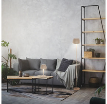 Modernes Wohnzimmer mit Stehleuchte und Tischleuchte mit plissiertem Schirm auf einem grauen Sofa.