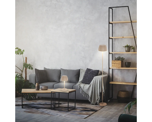 Modernes Wohnzimmer mit Stehleuchte und Tischleuchte mit plissiertem Schirm auf einem grauen Sofa.