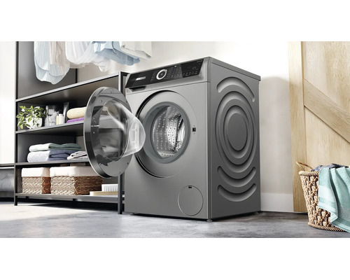 Bosch Waschmaschine mit offener Tür in einer Waschküche mit Regalen und Wäschekorb.