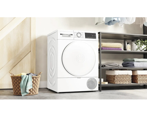 Bosch Wärmepumpentrockner in einer hellen Waschküche mit Regalen und Wäschekorb.