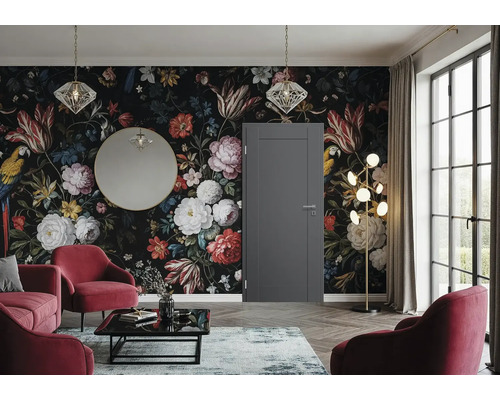 Eine elegante Zimmertür in einem modern eingerichteten Wohnzimmer mit blumiger Mustertapete, roten Sesseln und goldenen Akzenten.