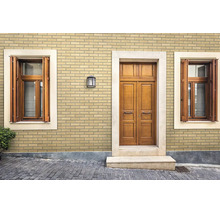 Fassade mit Klinkerriemchen in Ziegeloptik an einem Haus mit Holztüren und Fensterläden.