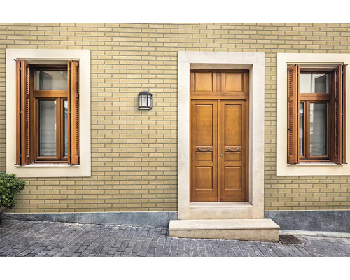 Fassade mit Klinkerriemchen in Ziegeloptik an einem Haus mit Holztüren und Fensterläden.