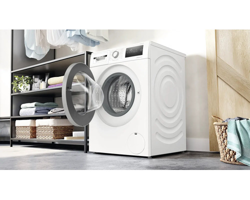 Bosch Waschmaschine mit offener Tür in einem modernen Hauswirtschaftsraum mit offener Regalkonstruktion und Wäschekorb.