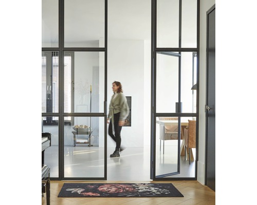 Heller Raum mit Stahlrahmentür, Teppich und einer Frau