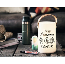 Eine dekorative Laterne mit Tragegriff und dem Schriftzug The Best Memories Are Made In A Camper auf einem Holztisch mit Stift.