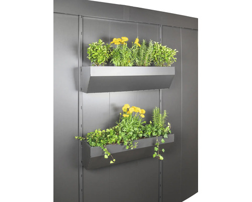 Zwei an einer Wand montierte Pflanzkästen aus Metall, bepflanzt mit verschiedenen Blumen und Kräutern für die vertikale Gartenarbeit.