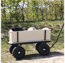 Ein Bollerwagen aus Holz mit vier großen Luftreifen steht auf einem Waldweg und ist mit einem Ball und einer Tasche beladen.