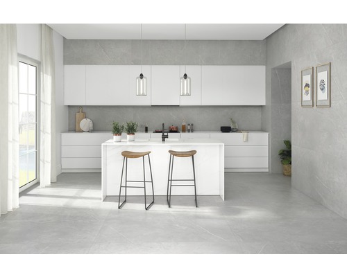 Helle Küche mit Kücheninsel, Barhockern und grauem Fliesenboden.