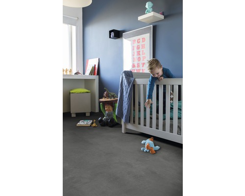 Kinderzimmer mit Bett, Spielzeug und grauem Bodenbelag.