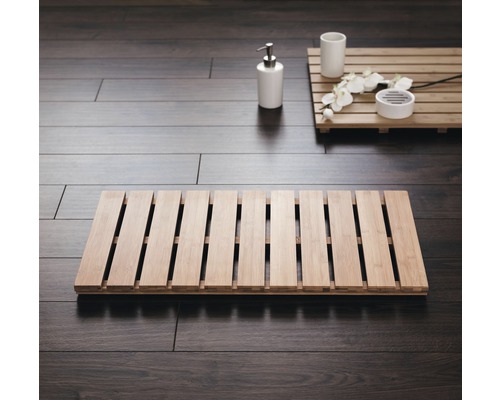 Badezimmer mit Badematte und Badaccessoires auf Holzboden