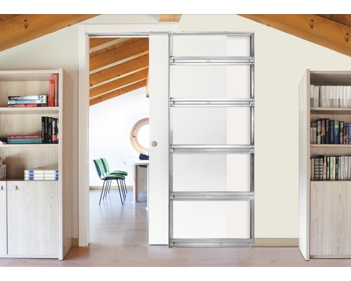 Modernes Interieur mit einem Schiebetürsystem aus Metall und Glas, das einen Blick in einen hellen Raum mit Holzbalken an der Decke freigibt.