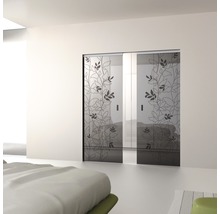 Zwei Glasschiebetüren mit Pflanzenmuster in einem hellen Schlafzimmer.