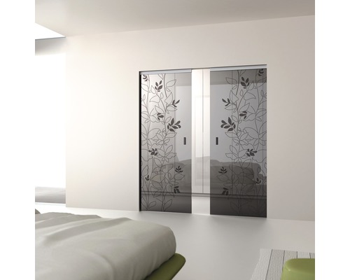 Zwei Glasschiebetüren mit Pflanzenmuster in einem hellen Schlafzimmer.