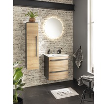 Badezimmer mit Waschtisch, Spiegelschrank und runden Spiegel mit Beleuchtung vor einer Steinwand