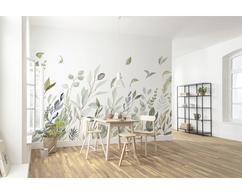 Helles Esszimmer mit Wandtattoo mit Blättermotiv, Holztisch und Stühlen