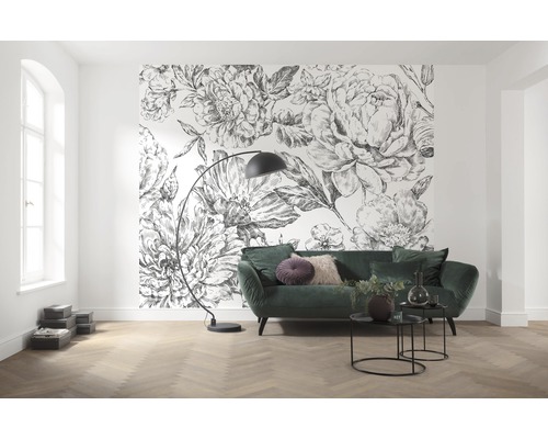 Wohnzimmer mit Blumenmustertapete, grünem Sofa und Stehlampe