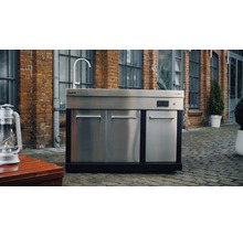 Outdoor-Küche mit Spüle, Schränken und Wasserhahn vor Backsteingebäude