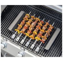 Grillspieße mit Fleisch und Gemüse auf einem Grillrost.