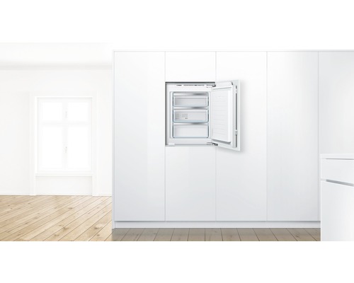 Eingebauter Gefrierschrank mit geöffneter Tür und drei Gefrierfächern in einer hellen Küche