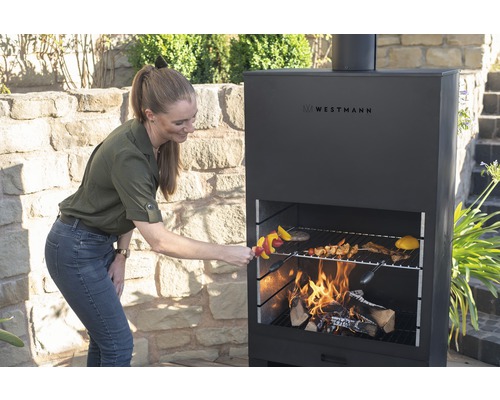 Frau grillt mit dem Westmann Grill im Garten