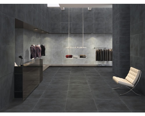 Innenraum mit grauen Fliesen an Boden und Wänden in einem Bekleidungsgeschäft.