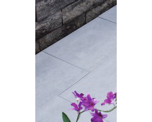 Nahaufnahme von grauen Terrassenplatten neben einer Steinmauer