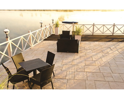 Außenbereich mit Steinterrasse, Gartenzaun, Sitzgruppe und Blick auf den See