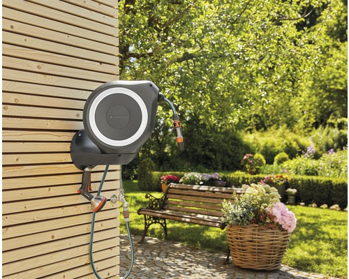Gartenszene mit Gardena Schlauchbox an einer Holzwand