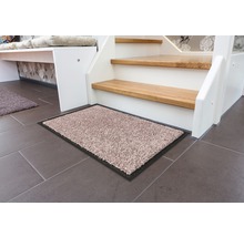 Schmutzfangmatte vor einer Treppe auf Fliesenboden.