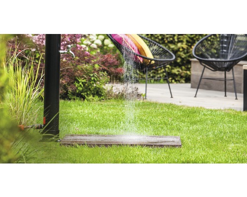 Gartenszene mit stehender Dusche, Rasen und Sitzgelegenheiten für den Außenbereich