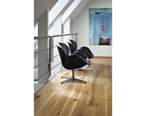 Drei schwarze Schalensessel auf Parkettboden in einem hellen Raum