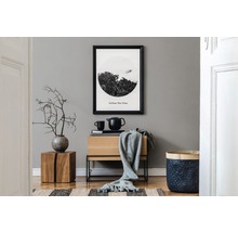 Dekoratives Wohnambiente mit Holzmöbeln, gerahmtem Bild und Wohnaccessoires