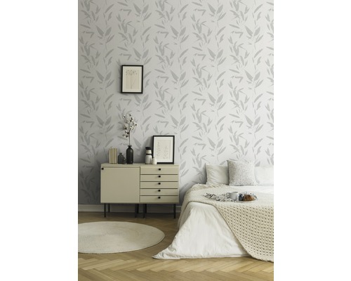 Helles Schlafzimmer mit gemusterter Tapete, Kommode und Bett