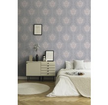 Schlafzimmer mit gemusterter Tapete, Kommode und Bett