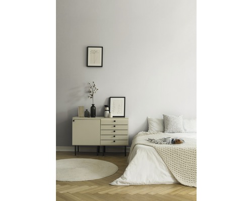 Schlafzimmer mit Kommode, Bett und runden Teppich