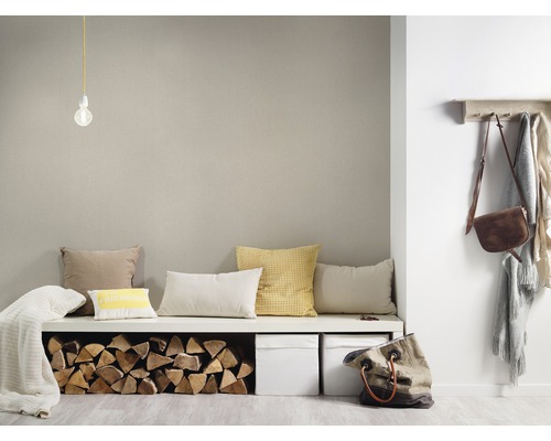 Wohnraum mit Sitzbank, Kissen, Holzscheiten, Aufbewahrungsboxen, Garderobe und Accessoires.