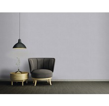 Wohnzimmer mit Sessel, Beistelltisch, Blumenvase und Pendelleuchte.