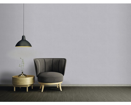 Wohnzimmer mit Sessel, Beistelltisch, Blumenvase und Pendelleuchte.