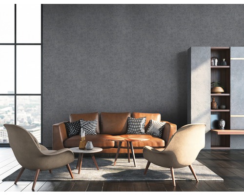 Wohnzimmer mit braunem Ledersofa, zwei Sesseln und grauer Wand