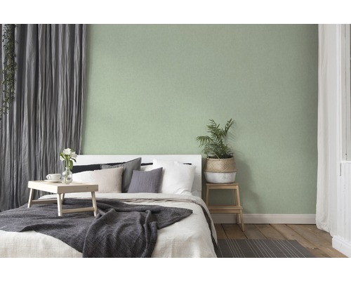 Schlafzimmer mit Bett, Vorhängen und grüner Wand