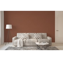 Wohnzimmer mit Couch, Kissen, Tisch und Stehlampe vor brauner Wand
