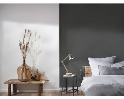 Dekoratives Schlafzimmer mit Tisch, Glasvase, Lampe und Bett