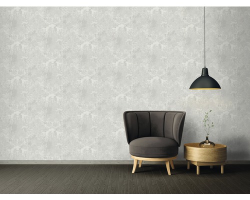 Wohnzimmer mit Sessel, Beistelltisch, Pendelleuchte und gemusterter Tapete