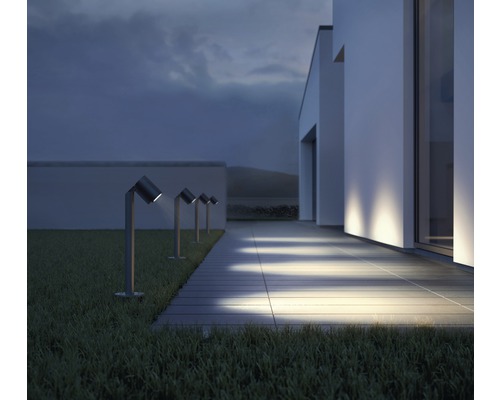 Reihe von Gartenleuchten entlang eines Gehwegs vor einem modernen Haus