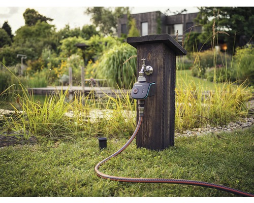 Bewässerungssteuerung mit Wasserhahn und Schlauch im Garten